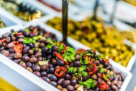 Assorted olives put up for sale on the italian street market stall.の写真素材