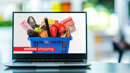 Laptop computer displaying a shopping basket with consumer goods. Online shopping. E-commerceの写真素材