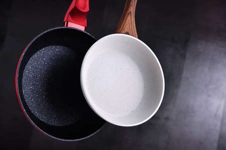 Two hanging stainless frying pans. Kitchen utensilsの写真素材