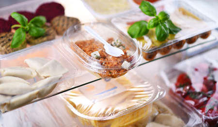 A variety of prepackaged food products in plastic boxes.