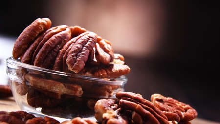 Composition with a bowl of shelled pecan nuts. Delicacies