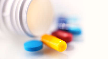 Composition with variety of drug pills and container.