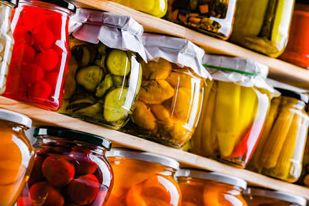 Jars with variety of marinated vegetables and fruits. Preserved food