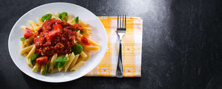 Composition with a plate of pasta penne rigateの写真素材