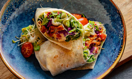 A bowl with two pieces of vegetarian tortillaの写真素材