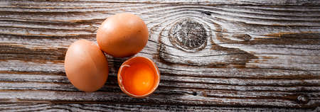 Composition with three chicken eggs on a wooden table.