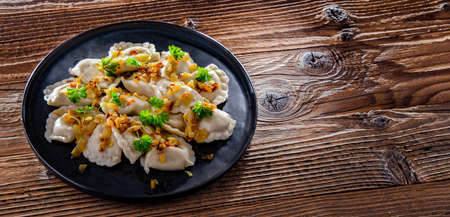 Composition with a plate of classic pierogies with onions.の写真素材