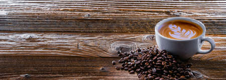 A cup of coffee on an old wooden table.