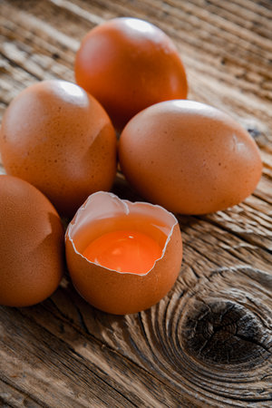 Composition with five chicken eggs on a wooden table.