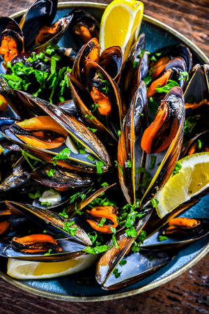 Composition with a plate of steamed mussels served with parsley and lemonの写真素材