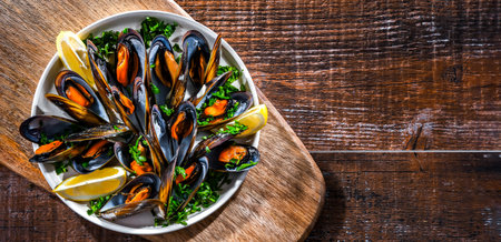 Composition with a plate of steamed mussels served with parsley and lemonの写真素材