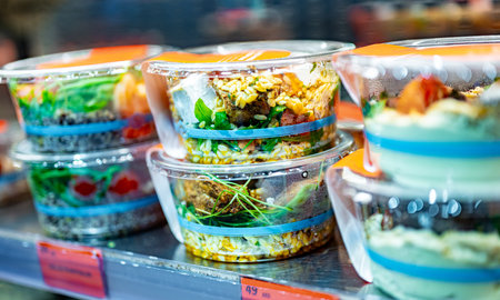 Pre-packaged meals displayed in a commercial refrigerator.の写真素材