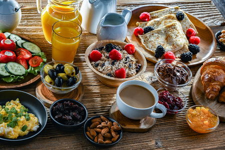 Breakfast served with coffee, orange juice, croissants, cereals, scrambled eggs and pancakes.の写真素材