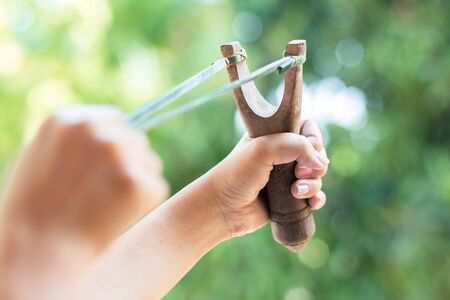 Human pulling slingshot and ready to fire.の写真素材