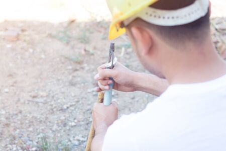 Worker fixing water pipe spinger in the garden.