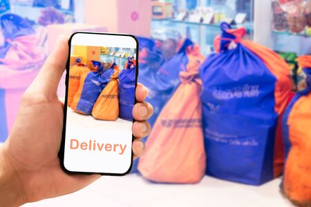 Holding mobile phone blurry background. delivery on mobile phone concept. mockup mobile for application design.の写真素材