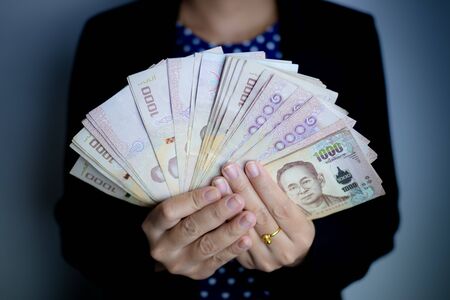 Femail hands holding banknotes on gray background.の写真素材