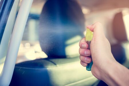 Hand spraying alcohol,disinfectant on  car handle (hand holder) in her car,prevent infection of Covid19,Coronavirus,nCoV,contamination of germ,bacteria,wipe clean surfaces are frequently touchの写真素材
