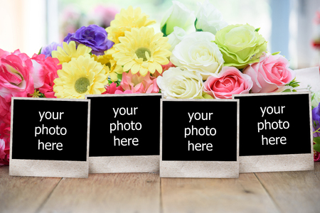 Blank vintage photo frame on wooden table with old books and flowers.Toned image.の写真素材