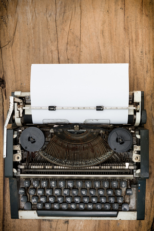 Top view image of old vintage typewriter with paper sheet. copy space for your text.On wooden background.の写真素材