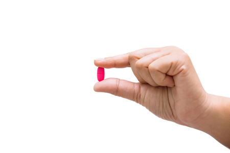 Medicine pills or capsules in hand, palm or fingers isolated on white background.の写真素材