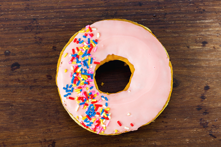 A strawberry donut on wooden backgroundの写真素材