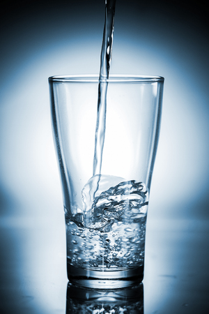 Water pouring in a glassの写真素材