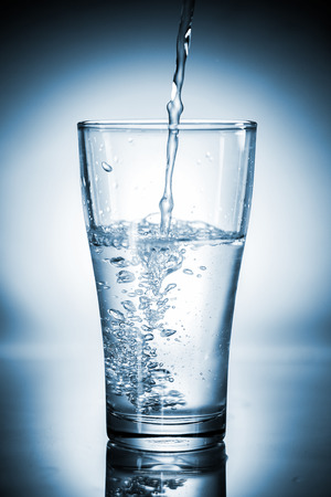 Water pouring in a glassの写真素材