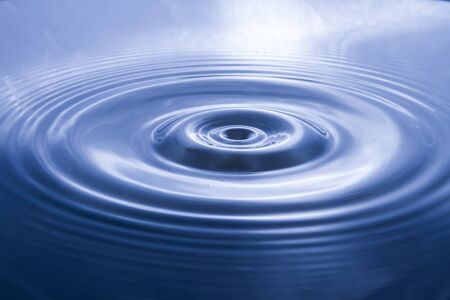 Blurry pictures of water waves created by water droplets and light blue water ripple backgroundsの写真素材