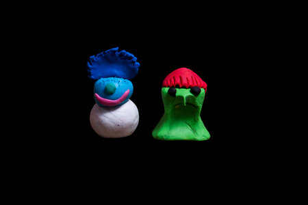 2 pieces of plasticine monster made in Halloween that are isolated from black clay.の写真素材