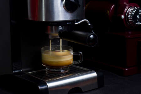Hot espresso flows into the cup. Making espresso in a clear glass coffee cupの写真素材