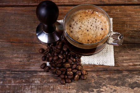A cup of coffee on a wooden table in the morning lightの写真素材