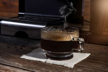 A cup of coffee on a wooden table in the morning lightの写真素材