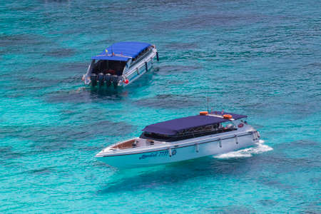 Two white speed boats are moored in the middle of the sea where the water is so clear that you can see the bottom of the sea.のeditorial素材