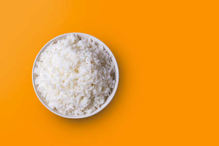 The rice was cooked in a white dish laying on an orange background with light coming in from the side, slightly shadowing. view from above ,Thai foodの写真素材