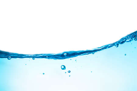 Water waves cause bubbles and splatter in clear blue water.の写真素材