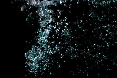 water waves with beautiful bubbles on a black background.の写真素材