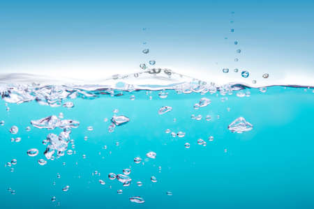 Bubbles floating in turquoise water on a blue backgroundの写真素材