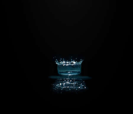 Water splashes cause the water distribution into a cylindrical shape. On a black background