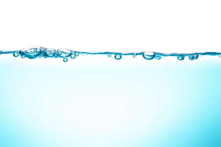 Water waves cause bubbles and splatter in clear blue water.の写真素材