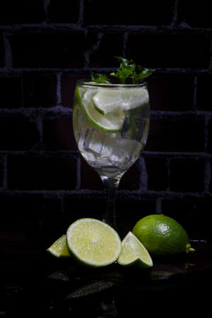 Lemon Soda with ice and fresh green leaves placed next to the black background lime.の写真素材