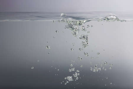 Many of the bubbles floating in the water are caused by waves on the surface. gray backgroundの写真素材
