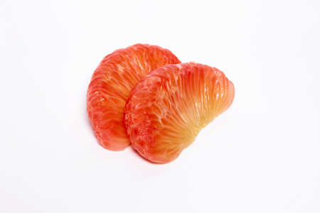 2 grapefruit peeled, orange-red flesh stacked on a white backgroundの写真素材