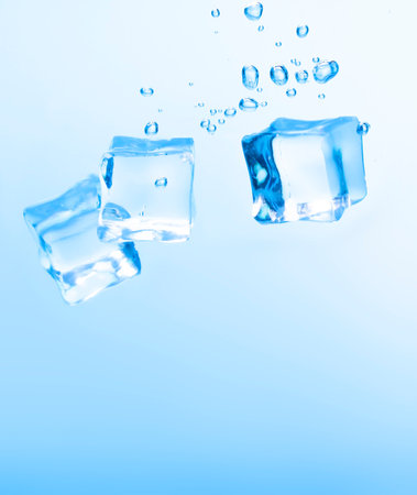 Ice cubes in blue water create bubbles that float to the surface, blue liquid.の写真素材