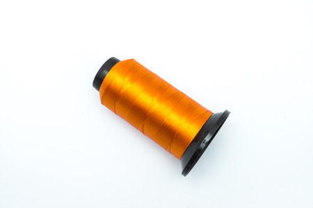 orange thread for sawing on white background