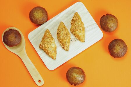 Croissant bread and Banana cake pasted on an orange backgroundの写真素材