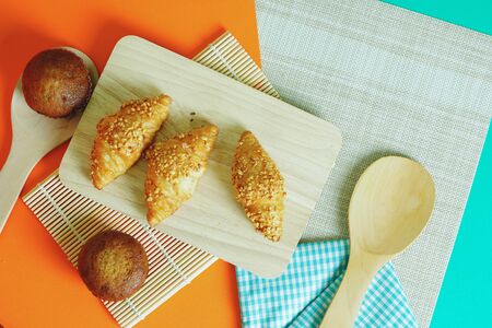 Croissant bread and Banana cake pasted on an orange green backgroundの写真素材