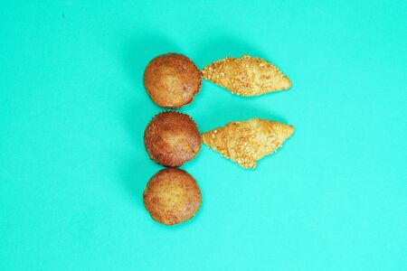 Croissant bread and Banana cake pasted on English alphabets an green backgroundの写真素材