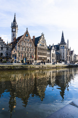 Panorama of Ghent, with the reflection of the houses in the river, on a sunny and cloudy day.の写真素材