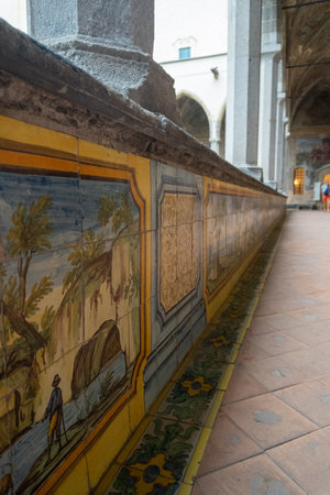 Interior of the cloister of Santa Chiara in Naples, with the pews lined with tiles on a cloudy day.のeditorial素材
